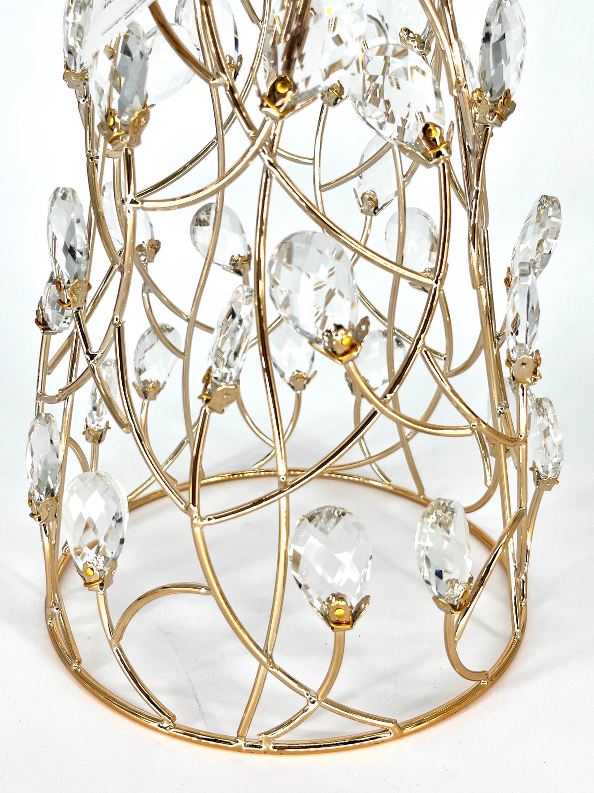 Close-up of the Mark Roberts Crystal Cone Tree's lower half: curved gold wire lattice set with clear faceted teardrop drops in small gold caps, rising from a round gold base ring.