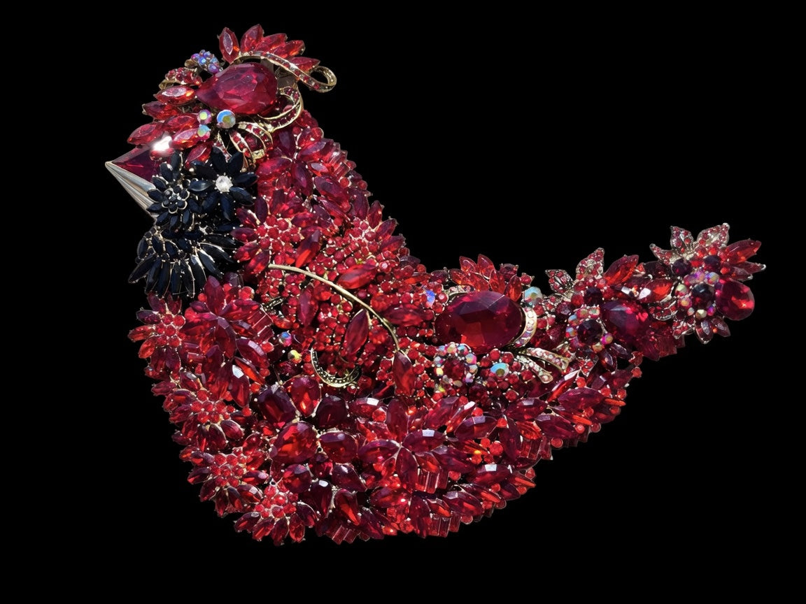 Red Cardinal Jeweled Sculpture against a black background, showcasing layered red rhinestones, aurora borealis accents, and jet-black face detail in gold metal setting — handmade in the USA