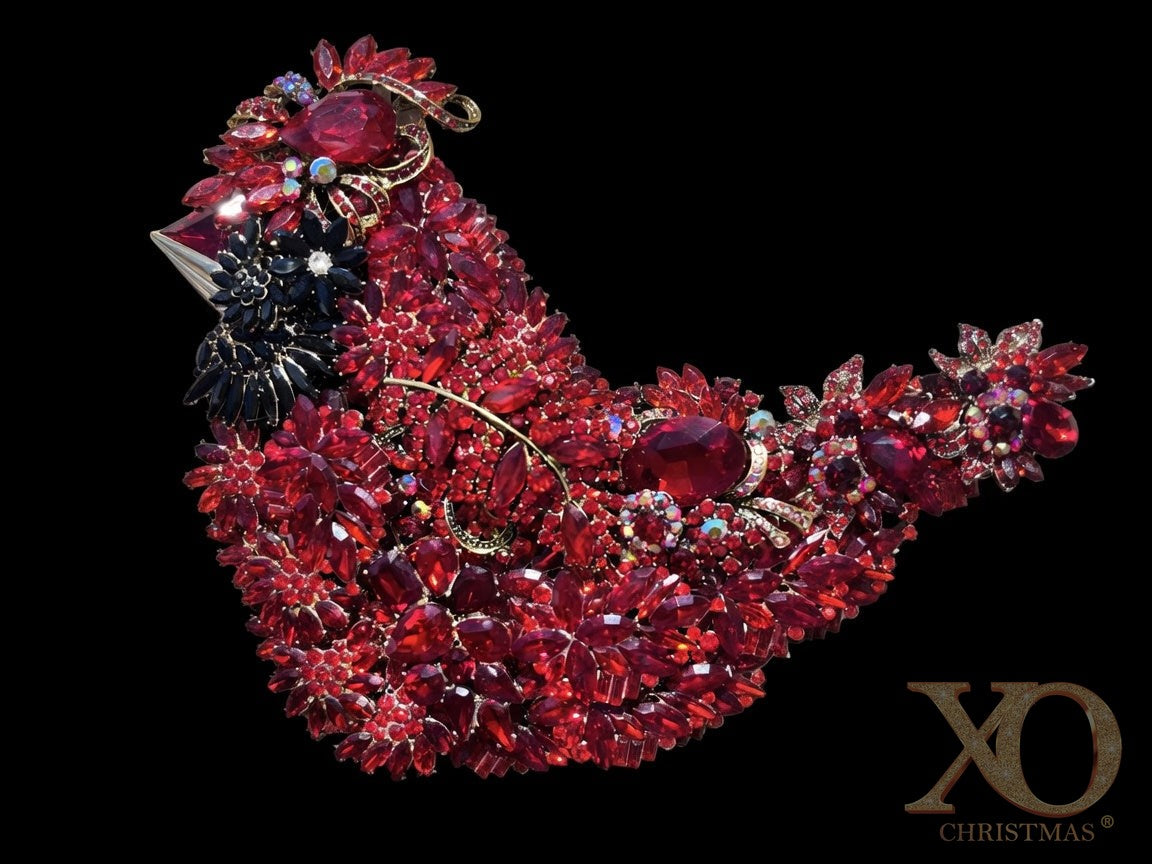 Red Cardinal Jeweled Sculpture against a black background, showcasing layered red rhinestones, aurora borealis accents, and jet-black face detail in set in gold-tone metal