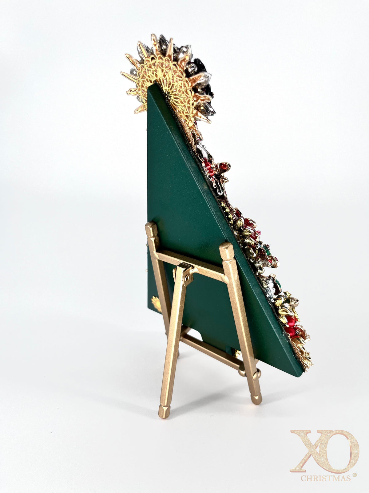 Side view of Christmas tree jeweled art showing green backing displayed on gold easel 