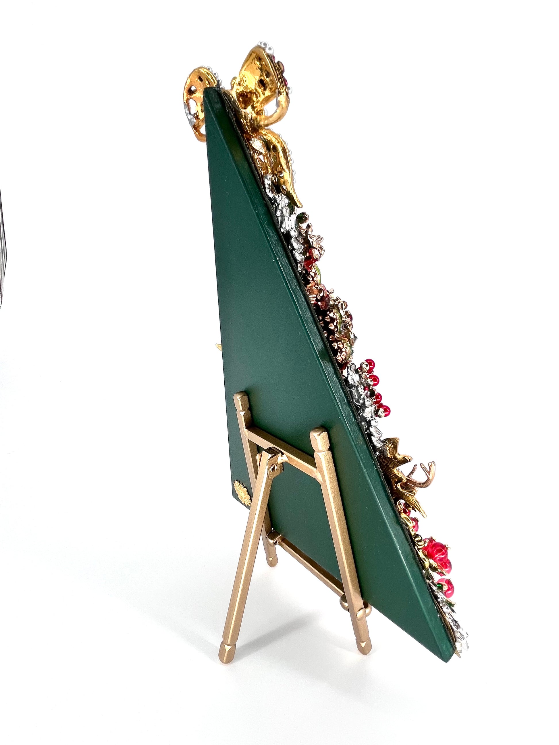 Back angle view of jeweled Christmas tree sculpture on gold easel, showing green backing and dimensional rhinestone embellishments