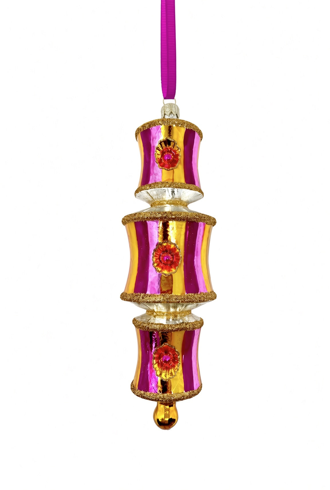 Three-tiered glass ornament in glossy fuchsia and gold vertical stripes, each tier edged in gold glitter with a round ruby reflector medallion centered on the front, joined by silver connector rings, ending in a small gold ball finial, with a fuchsia ribbon at top for hanging.