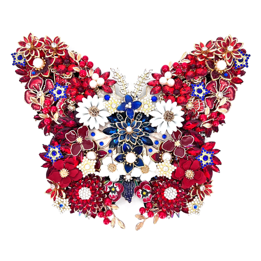 A highly detailed, symmetrical butterfly-shaped jeweled  decorative piece composed of red, white, and blue floral elements with gold-toned metal settings, shown against a plain white background.