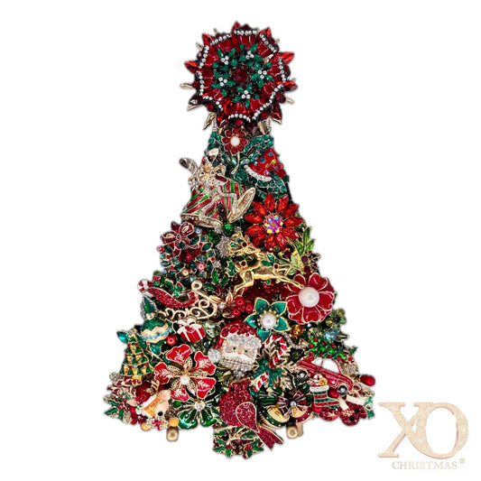 A Christmas tree-shaped jeweled tree made densely with crystal and rhinestone red, green, gold, and silver holiday-themed jewelry elements, including floral motifs, ornaments, and a star topper, shown on a plain white background.
