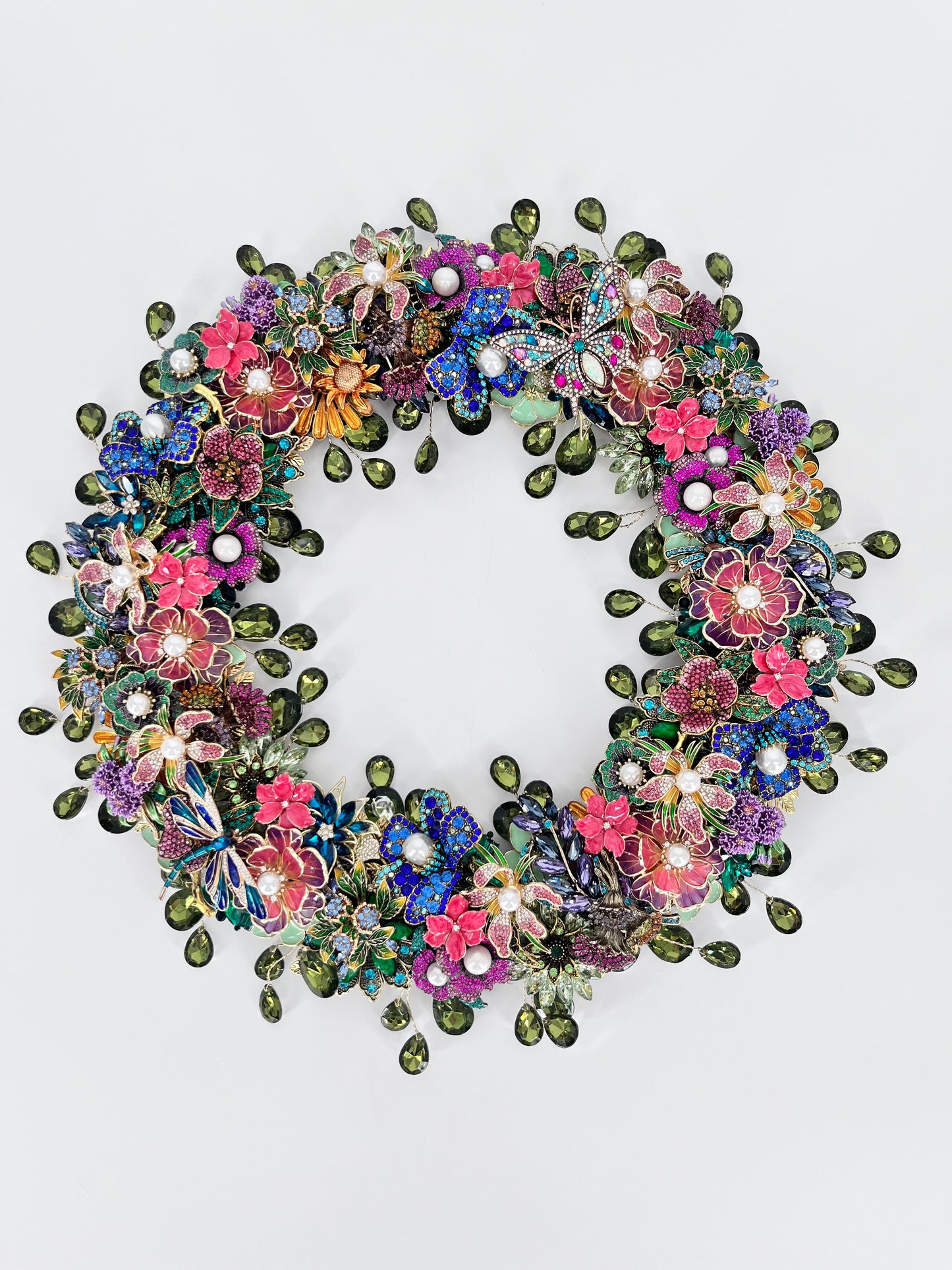 Jeweled wreath with sage green teardrop  rhinestones, pearl-centered florals, jeweled butterflies, and multicolor rhinestone blooms in pink, purple, blue, and fuchsia