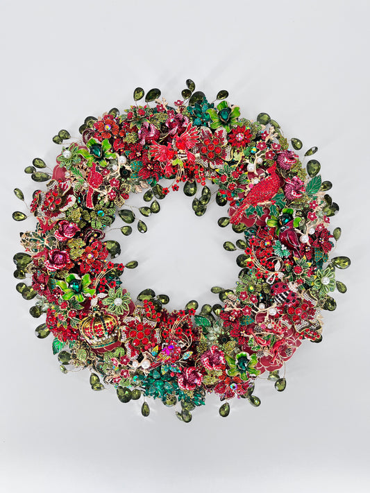 Layered with rhinestone florals in rich red, deep green enamel leaves, colorful jeweled accents, select vintage brooch details, several cardinal figures, and a jeweled crown