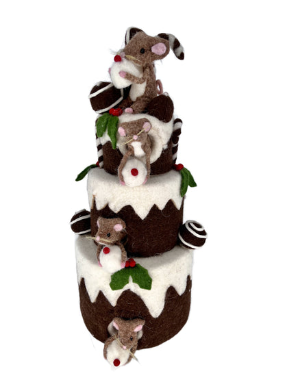Brown felt Christmas mice climbing a chocolate three-tier cake centerpiece with white icing, green holly, red berries and truffles