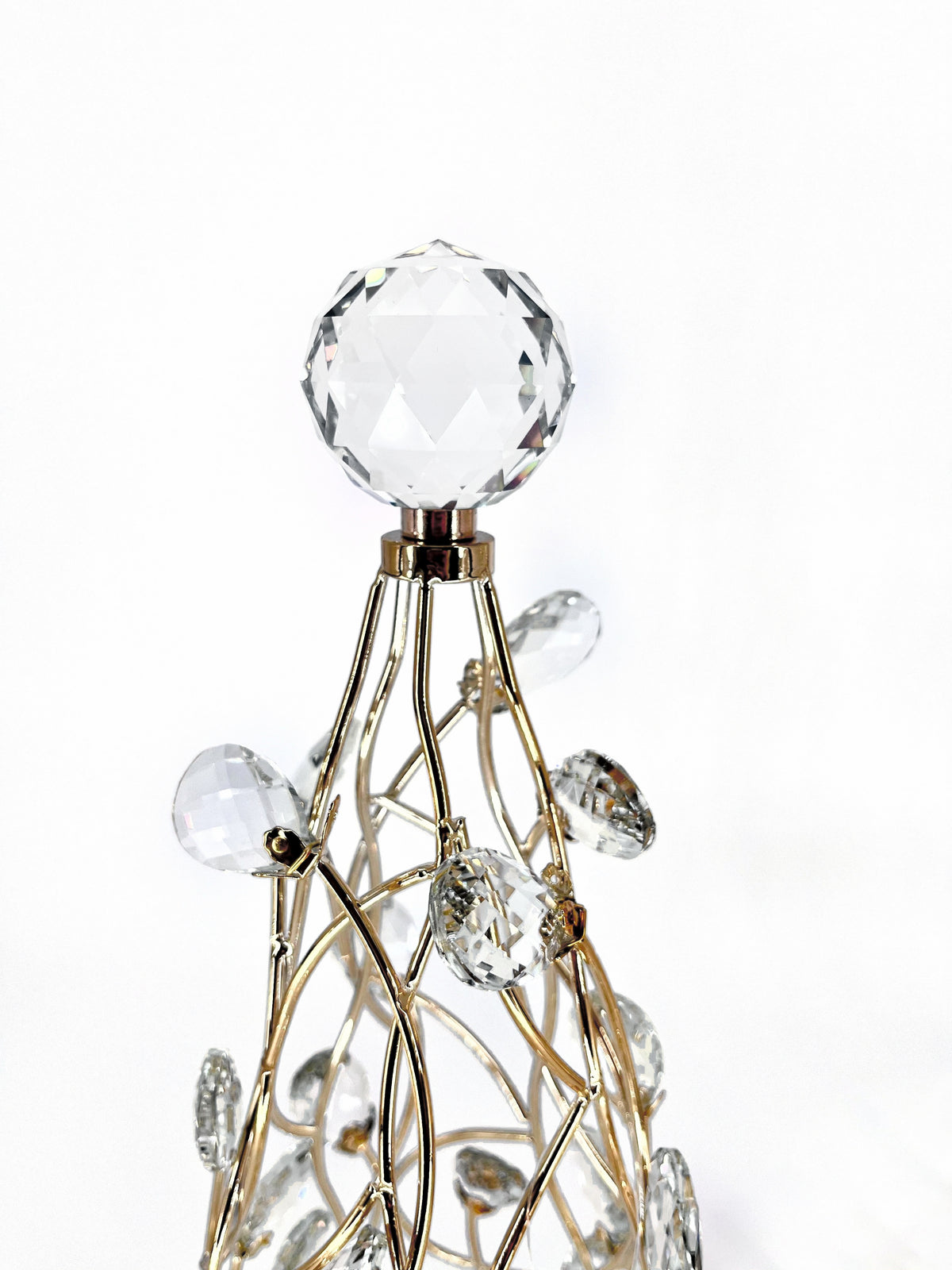Close-up of the Mark Roberts Crystal Cone Tree's top: a large clear faceted ball topper on a gold collar, above gold wire lattice hung with clear faceted teardrop drops.