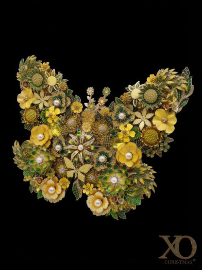Sunshine Flight jeweled butterfly wall art at a slight angle against a black background, showing dimensional depth — composed of yellow flowers, green leaves, and a dense arrangement of jeweled accents and pearl-like centers.