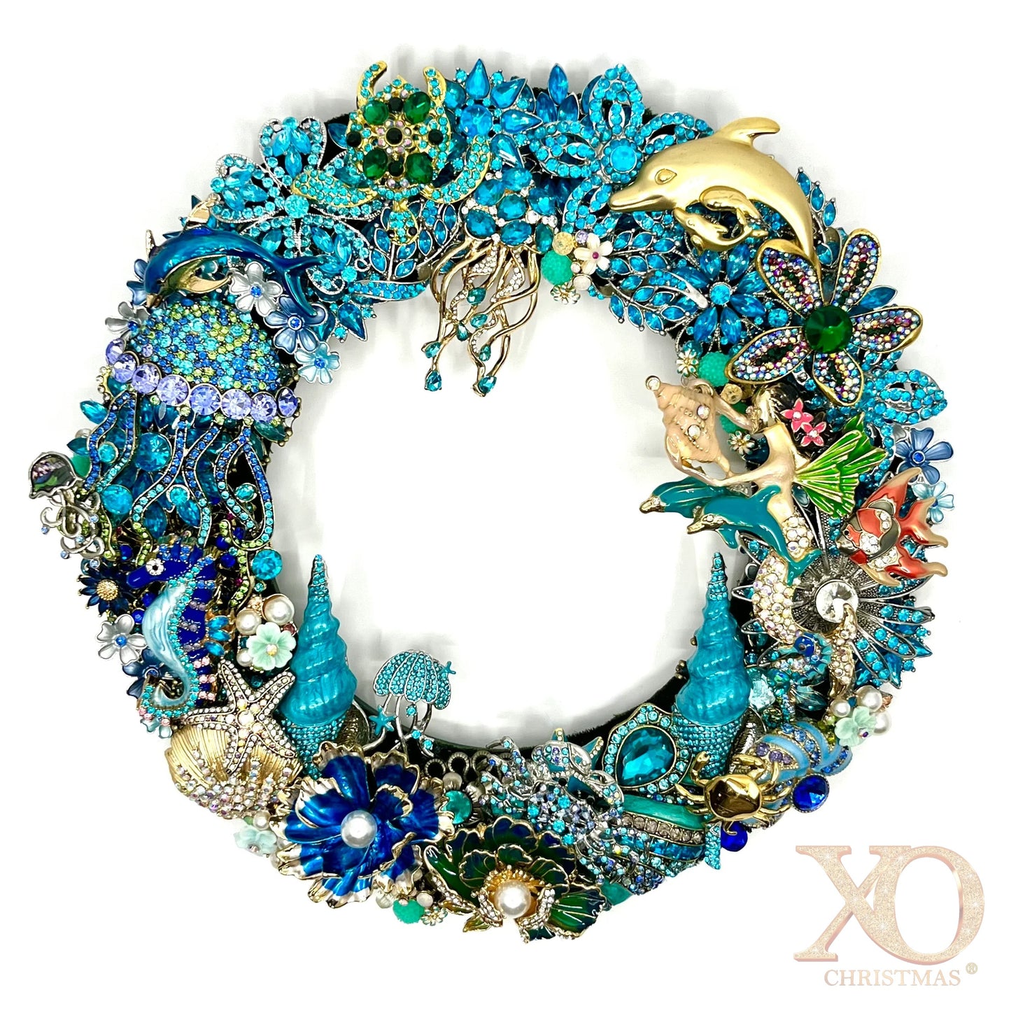 Handmade coastal Christmas wreath of blue and gold jeweled brooches shaped into dolphins, seahorses, starfish, shells and coral.