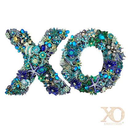 Heavily jeweled XO ocean wreath set in blue, teal, and green, adorned with tropical fish, starfish, and seahorse motifs