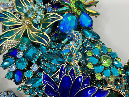 Close-up of a heavily jeweled ocean wreath with a jeweled seahorse among sapphire and emerald rhinestone blooms