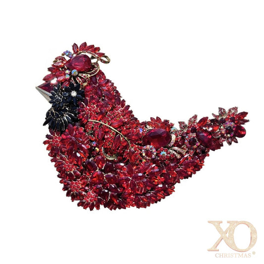 Suggestion


Layers of red rhinestone in the shape of a bird representing the cardinal. Embellished with numerous red and dark red faceted rhinestones, set in gold-tone metal with a small black floral accent on the side, shown against a plain white background. 